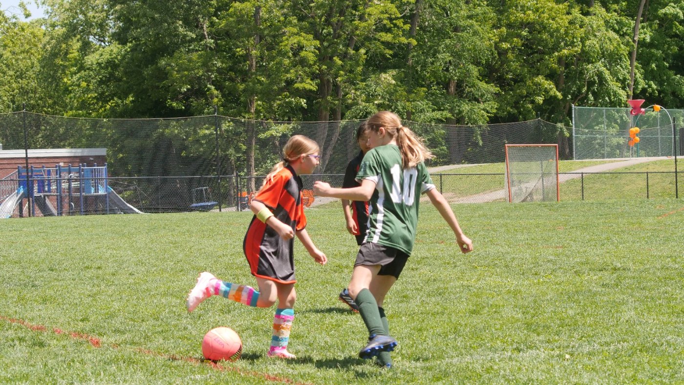 Youth soccer players competing on a sunny field